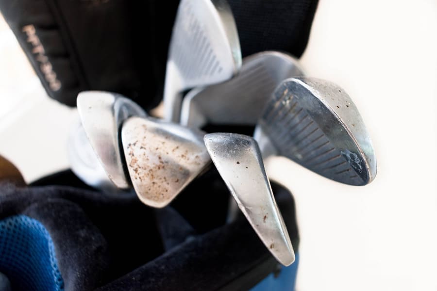 A close-up look of rusted golf clubheads placed in a golf bag