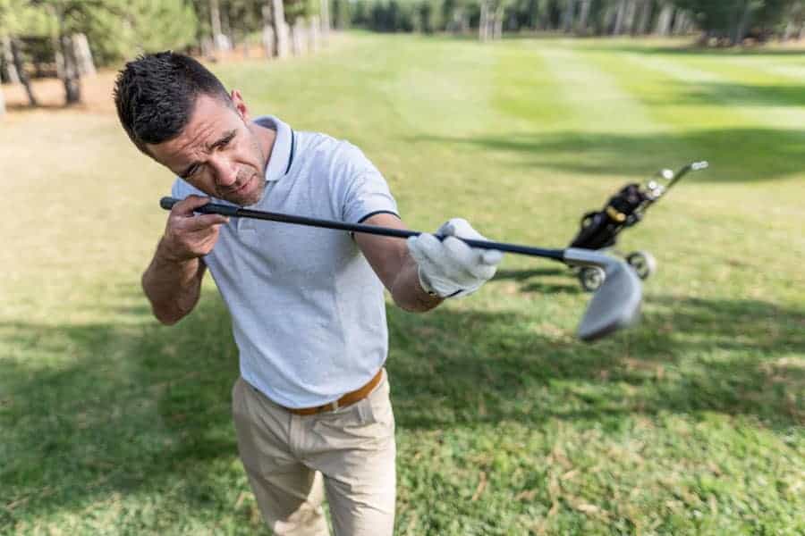 A golfer is seen checking the shaft flex for a better shot.