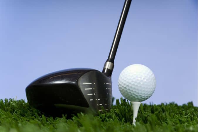 Golf Driver is placed near to the golf ball tee.