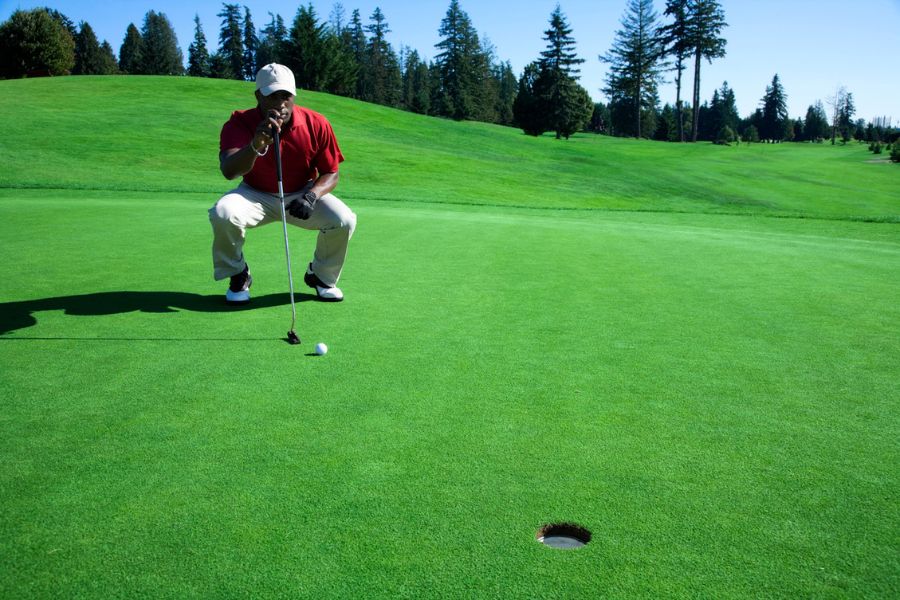 A golfer is observing its shot on the golf course