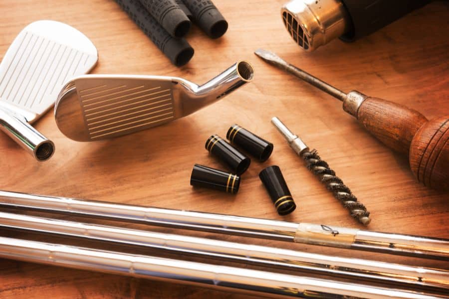 Tools spread on table to fit the golf clubs - How Much Do Fitted Golf Clubs Cost?