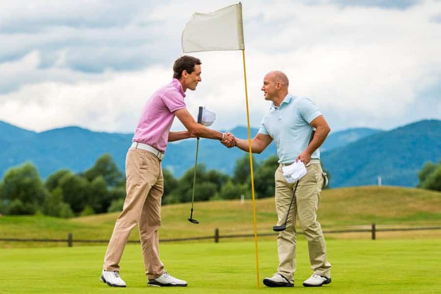 Two golfers shaking hand when playing golf playoff on the golf course.