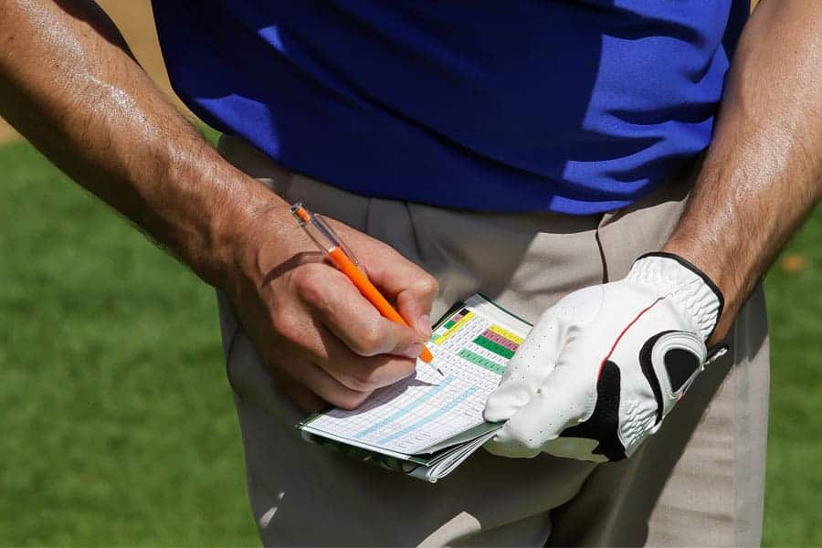 A golfer is filling the scores in the socrecard.