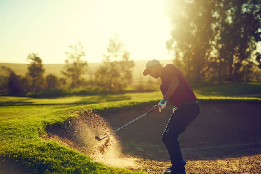 A golfer is hitting a bunker shot